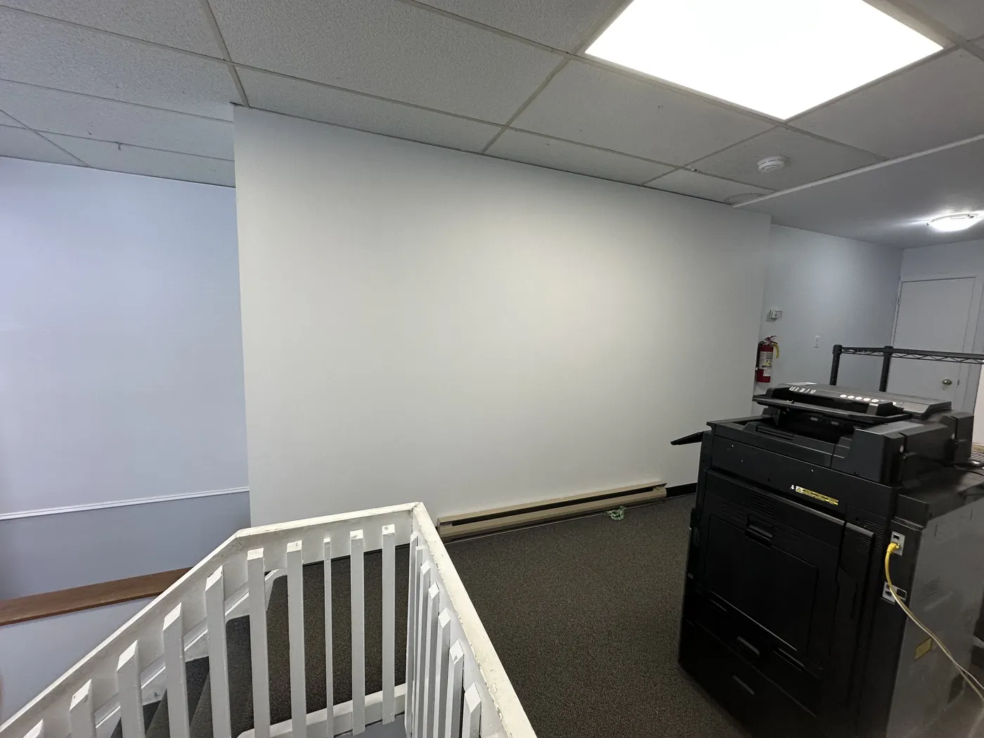 Commercial office space with white railings and cubicles freshly painted by All In One Painting in North Bay