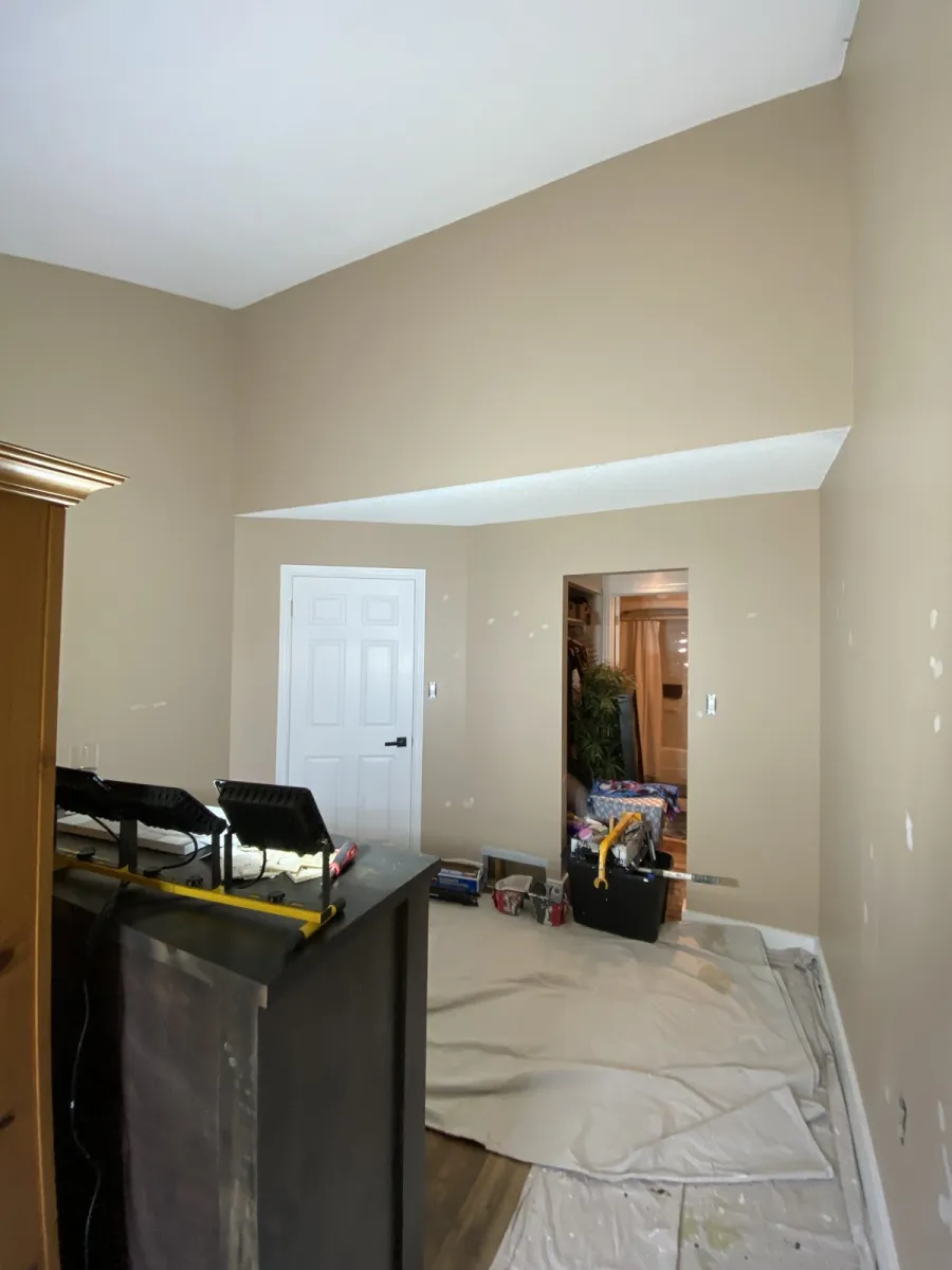 Hallway and entry interior in mid-prep with primer and drop cloths